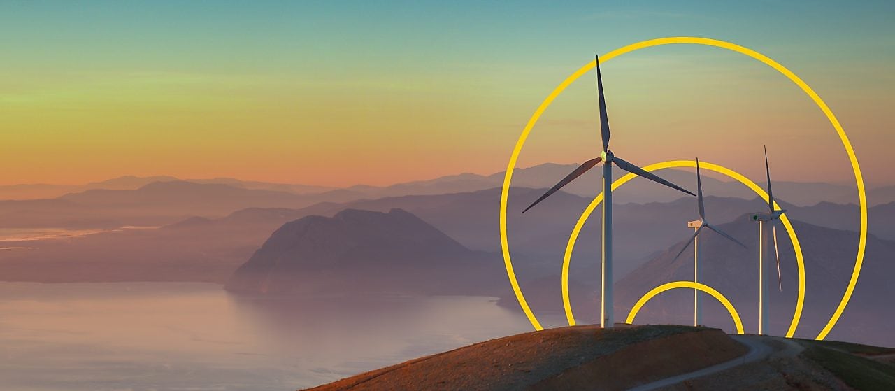 Foto de tres turbinas eólicas en una colina con un resumen del gráfico de Obtención de cero emisiones netas.