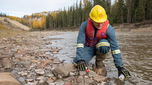 Empleado de Shell recogiendo agua del río