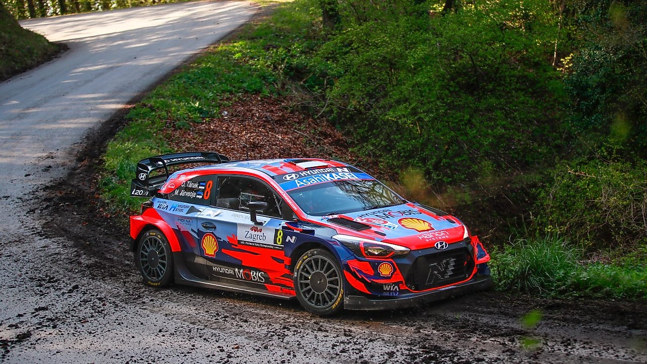 Coche de rally corriendo a gran velocidad al amanecer en el Campeonato del Mundo de Rally