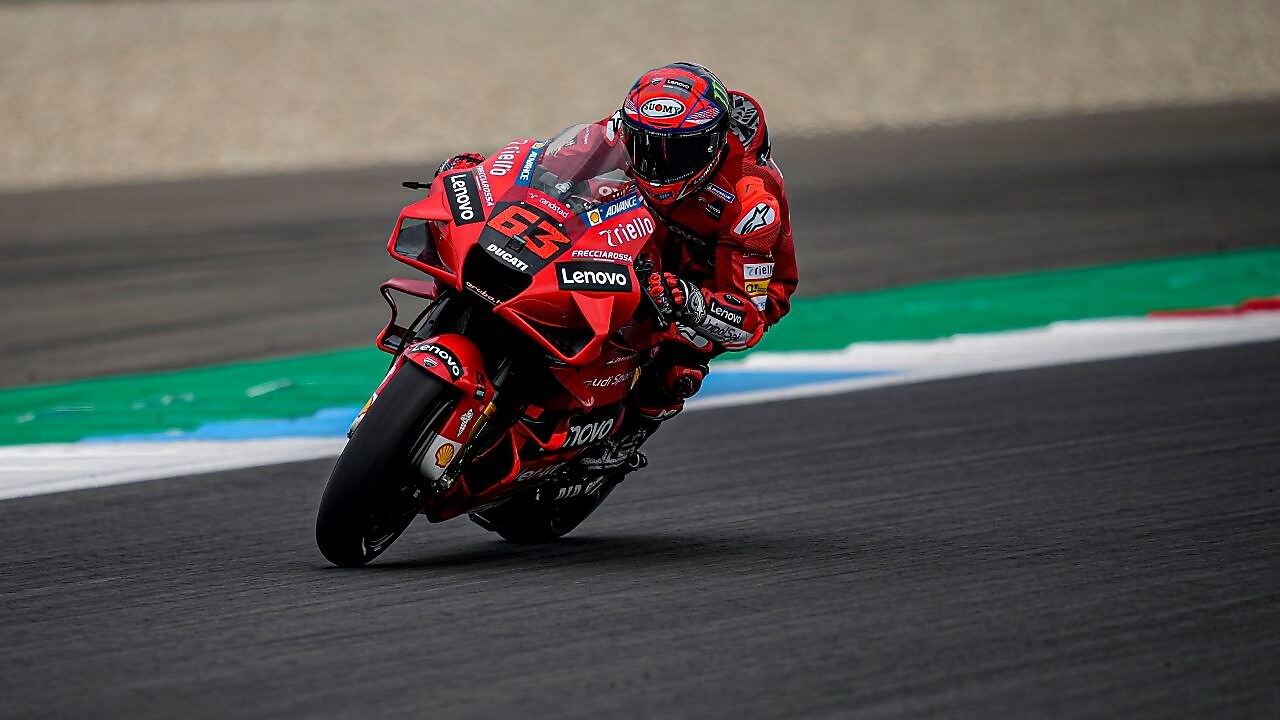 Superbike y piloto de Ducati corriendo por una curva de la pista
